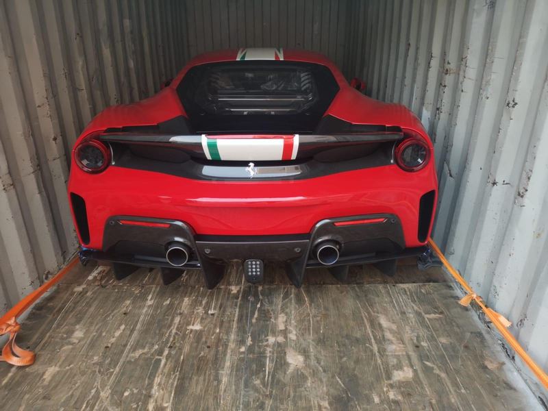 Red Ferrari 488 Pista in a shipping container