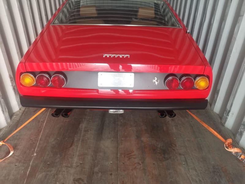 Classic red Ferrari secured in a shipping container