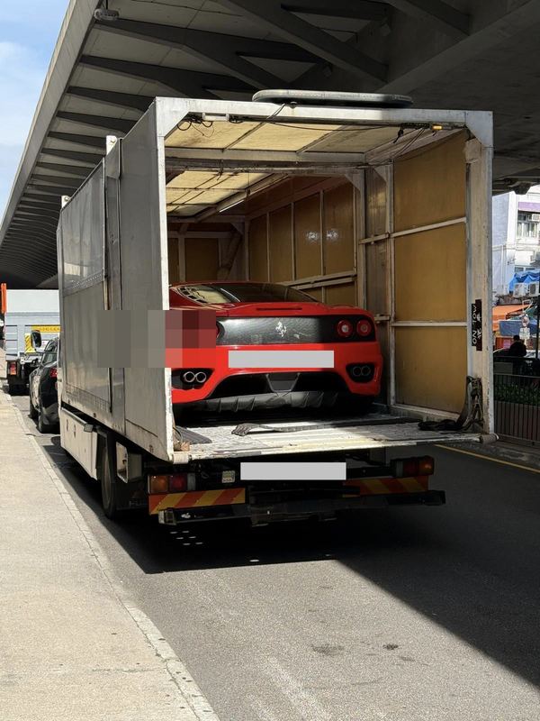 Red Ferrari 360 on an enclosed transport truck