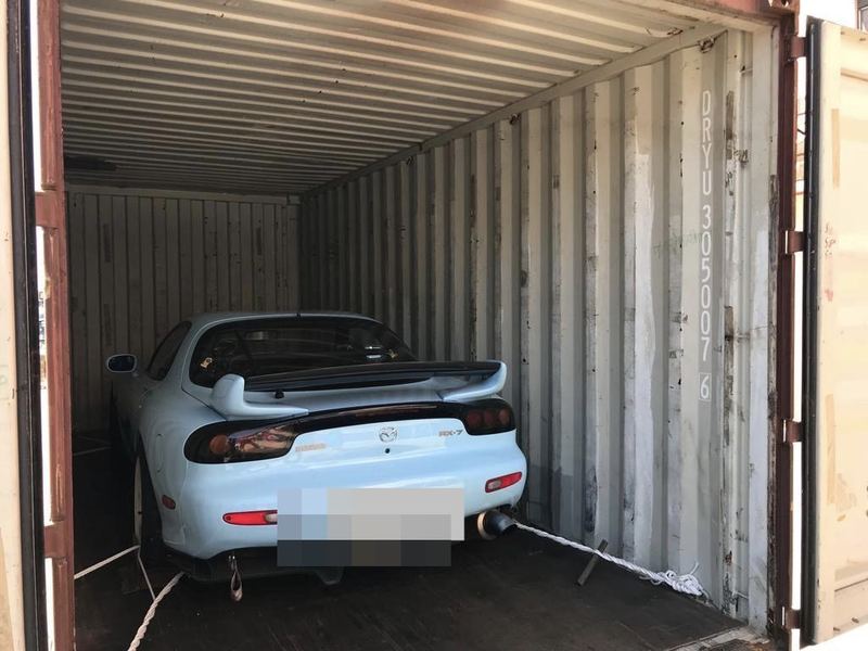 Light blue Mazda RX-7 in a shipping container