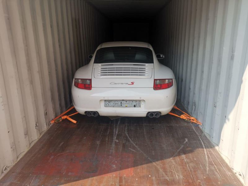 White Porsche 911 Carrera S in a shipping container