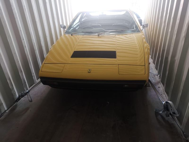Classic yellow Ferrari in a shipping container